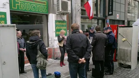 Wybita witryna sklepu w centrum. Regały i lodówki na chodniku