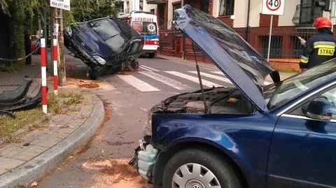 Opel "zawisł" na słupie. Dziecko w szpitalu