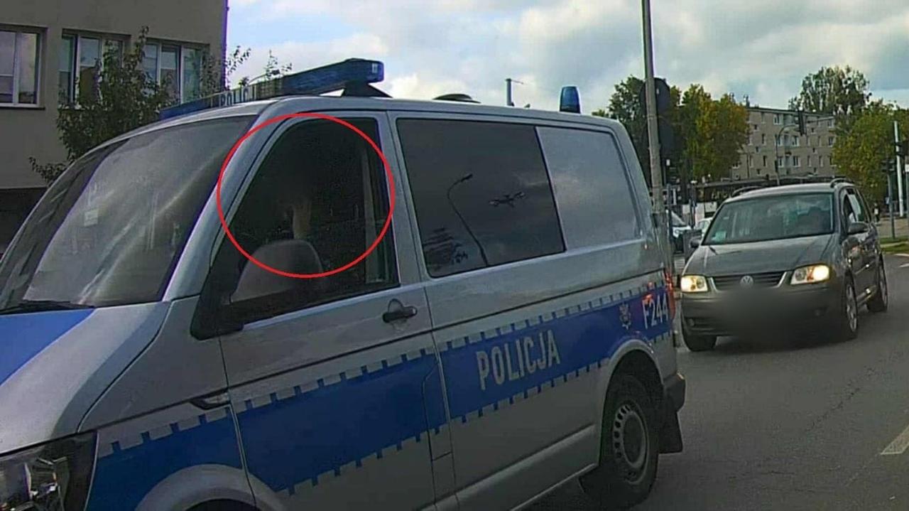 Policjantka z telefonem przy uchu w radiowozie. "Jest to dla nas bolesne"