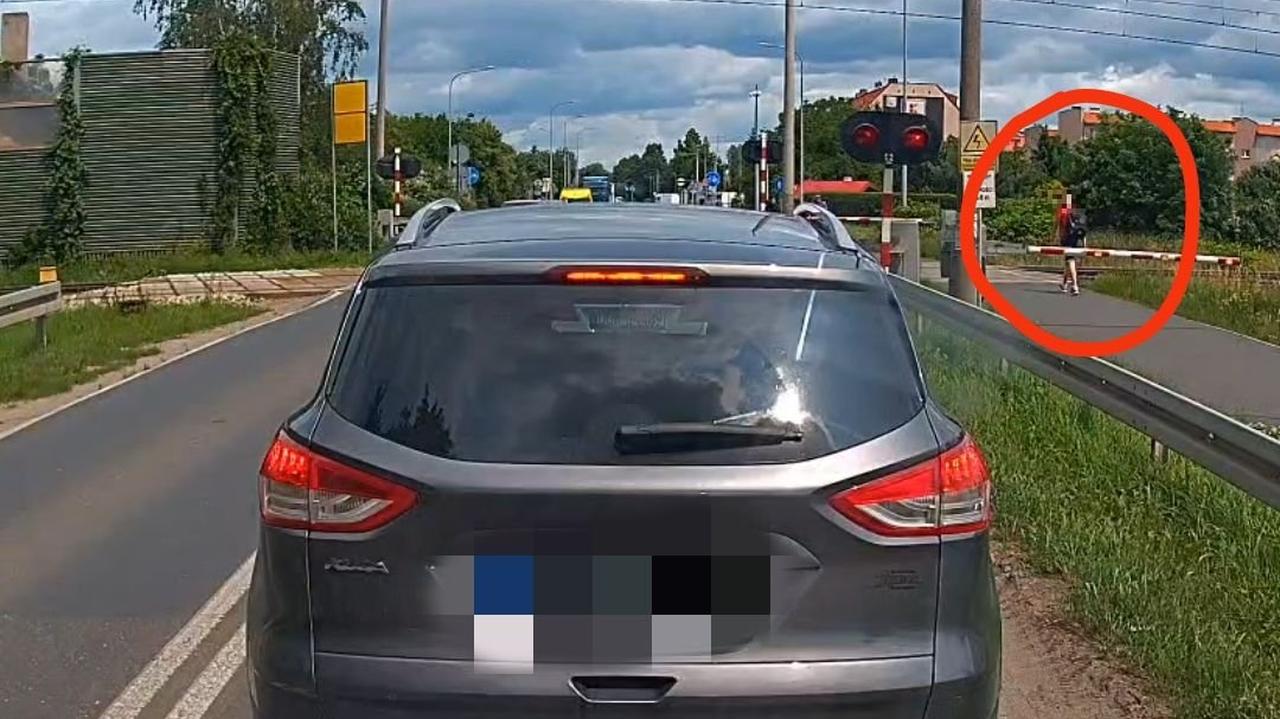 Jest czerwone światło, ale on przechodzi. Po kilku sekundach przejeżdża pociąg