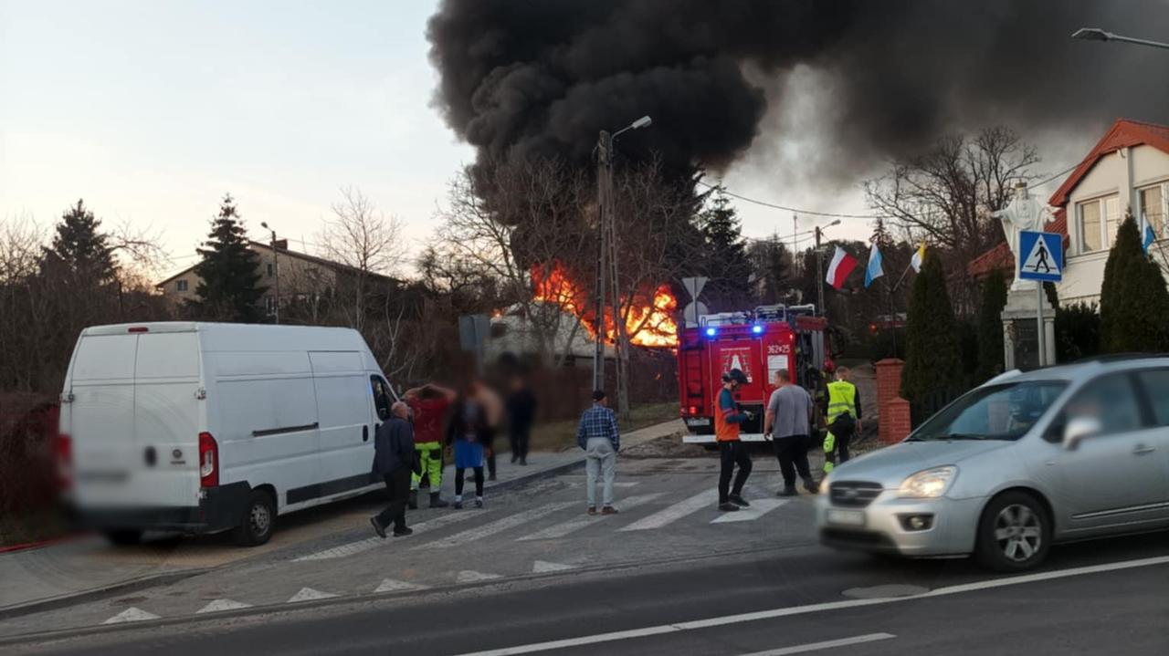 Ciężarówka w płomieniach, kłęby dymu nad miastem