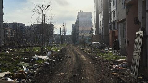 Rosyjski żołnierz wiesza flagę na budynku w ukraińskim Wuhłedarze 