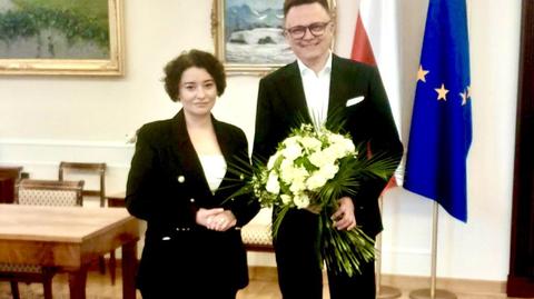 Żukowska z bukietem kwiatów, przeznaczonych dla marszałka Sejmu 
