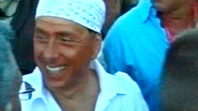 Berlusconi w białej chuście na głowie