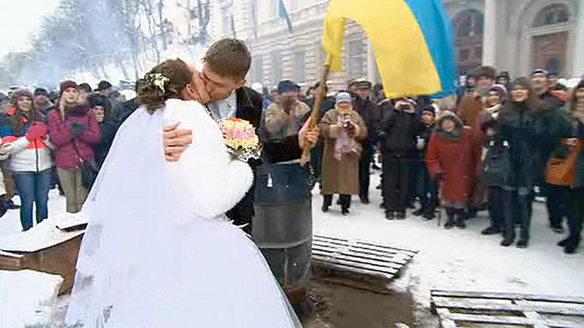 Sesja ślubna na barykadach. Młodzi z ukraińską flagą i protestującymi