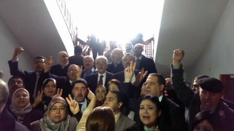 Uwięzieni w parlamencie. Deputowani śpiewają hymn Tunezji