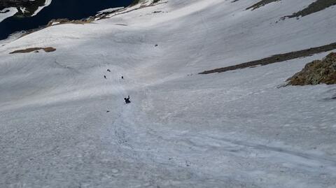 Turyści na siedząco zjeżdżali po śniegu w rejonie Szpiglasowej Przełęczy