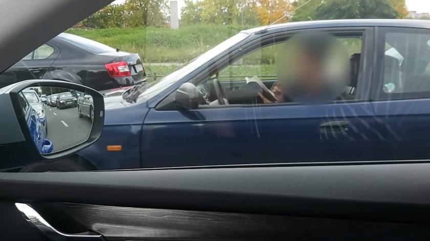 Kierowca czyta książkę podczas jazdy
